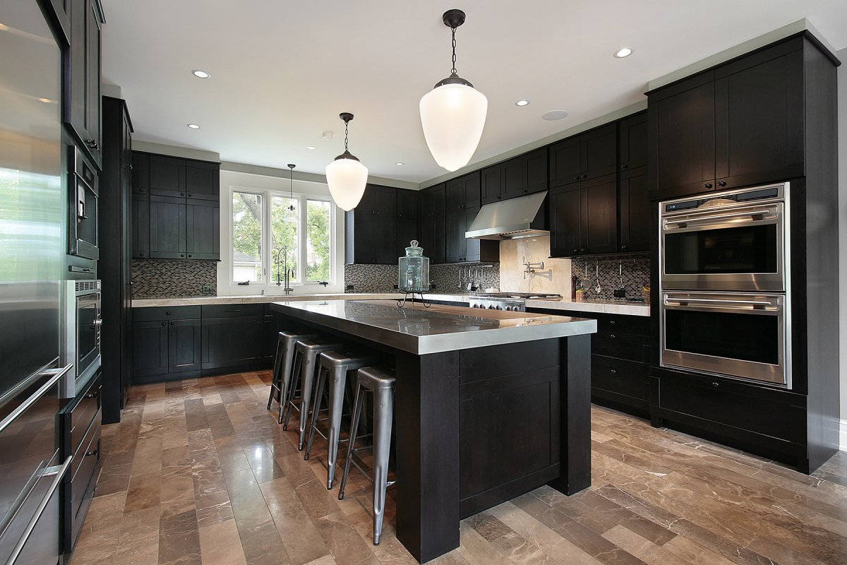 Duża kuchnia w ciemnym odcieniu drewna. 
